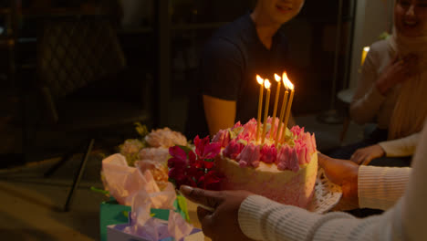 Multikulturelle-Gruppe-Feiert-Den-Geburtstag-Von-Freunden-Zu-Hause-Mit-Kuchen-Und-Kerzen-Auf-Der-Party